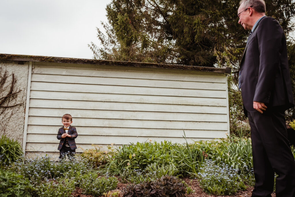 bride and grooms son hides amongst the flowers at sheene mill wedding