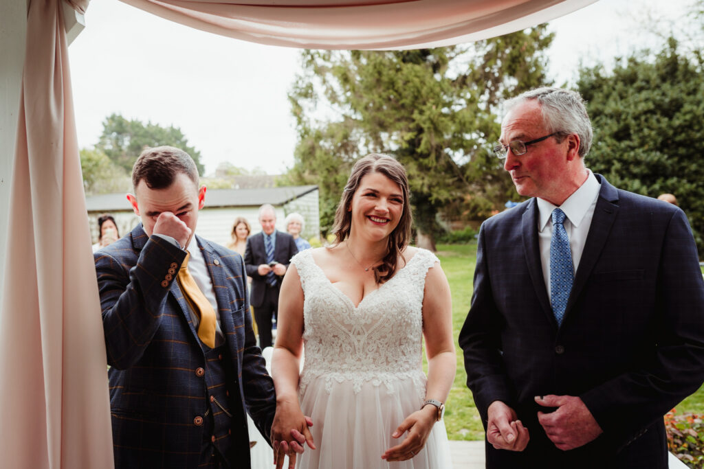 groom sheds a tear during outdoor wedding ceremony at sheene mill cambridgeshire