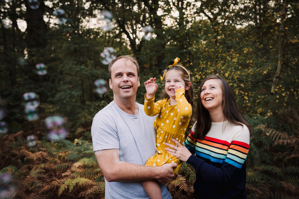 Bubbles make a family giggle during their family photo shoot in Hertfordshire woods