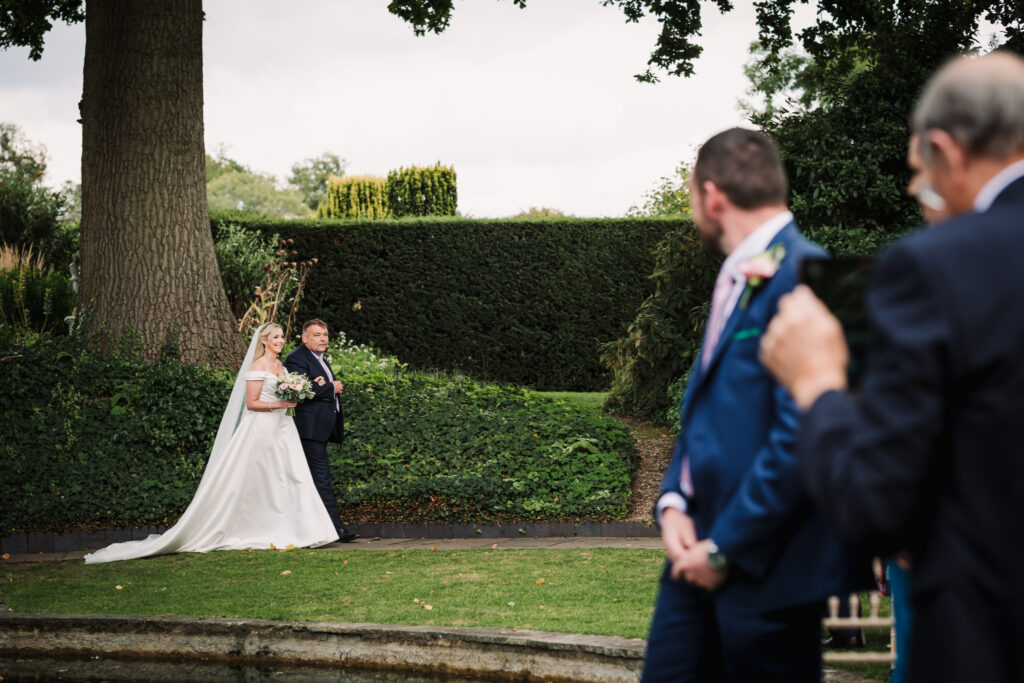 bride arrives for the wedding ceremony at micklefield hall hertfordshire