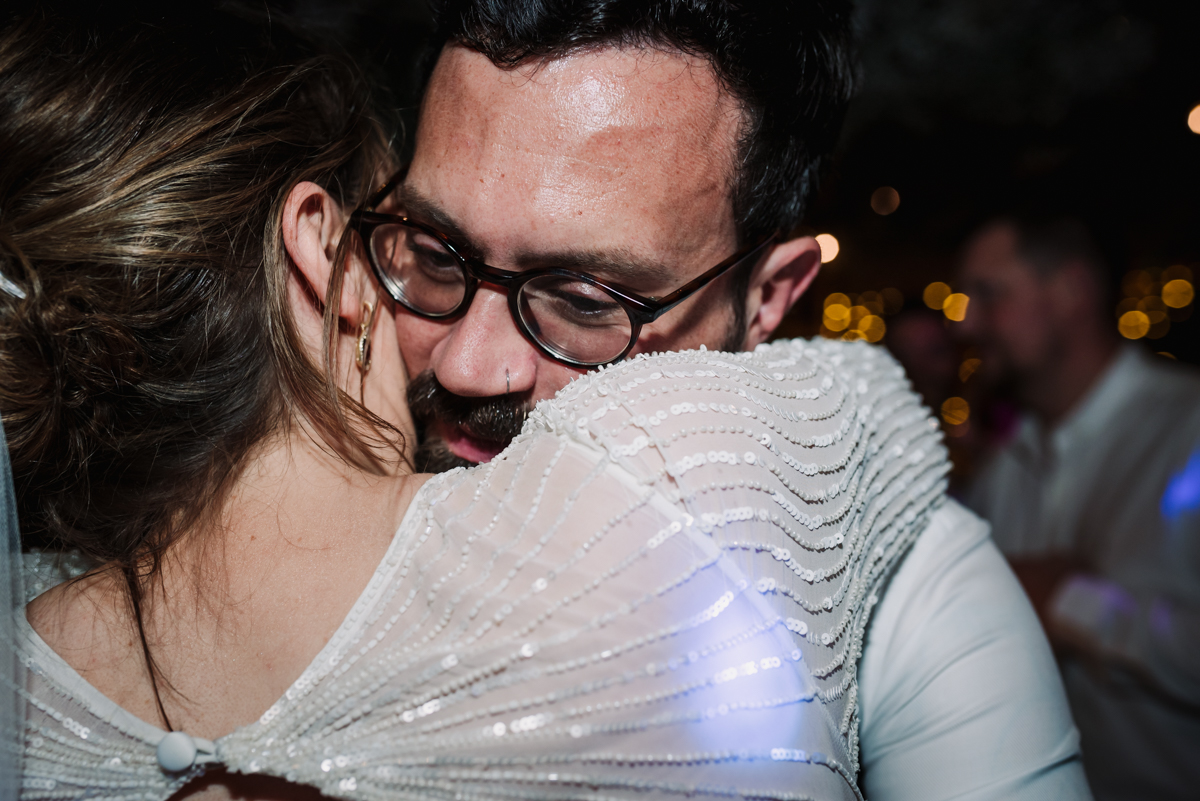 Bride and groom hug tightly during their wedding reception at The Barns at redcoats
