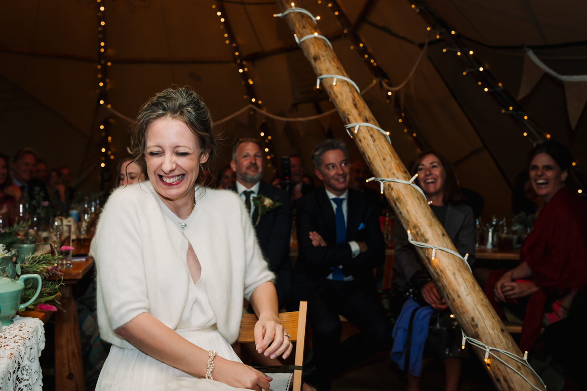 Bride giggles during the wedding speeches in Hertfordshire