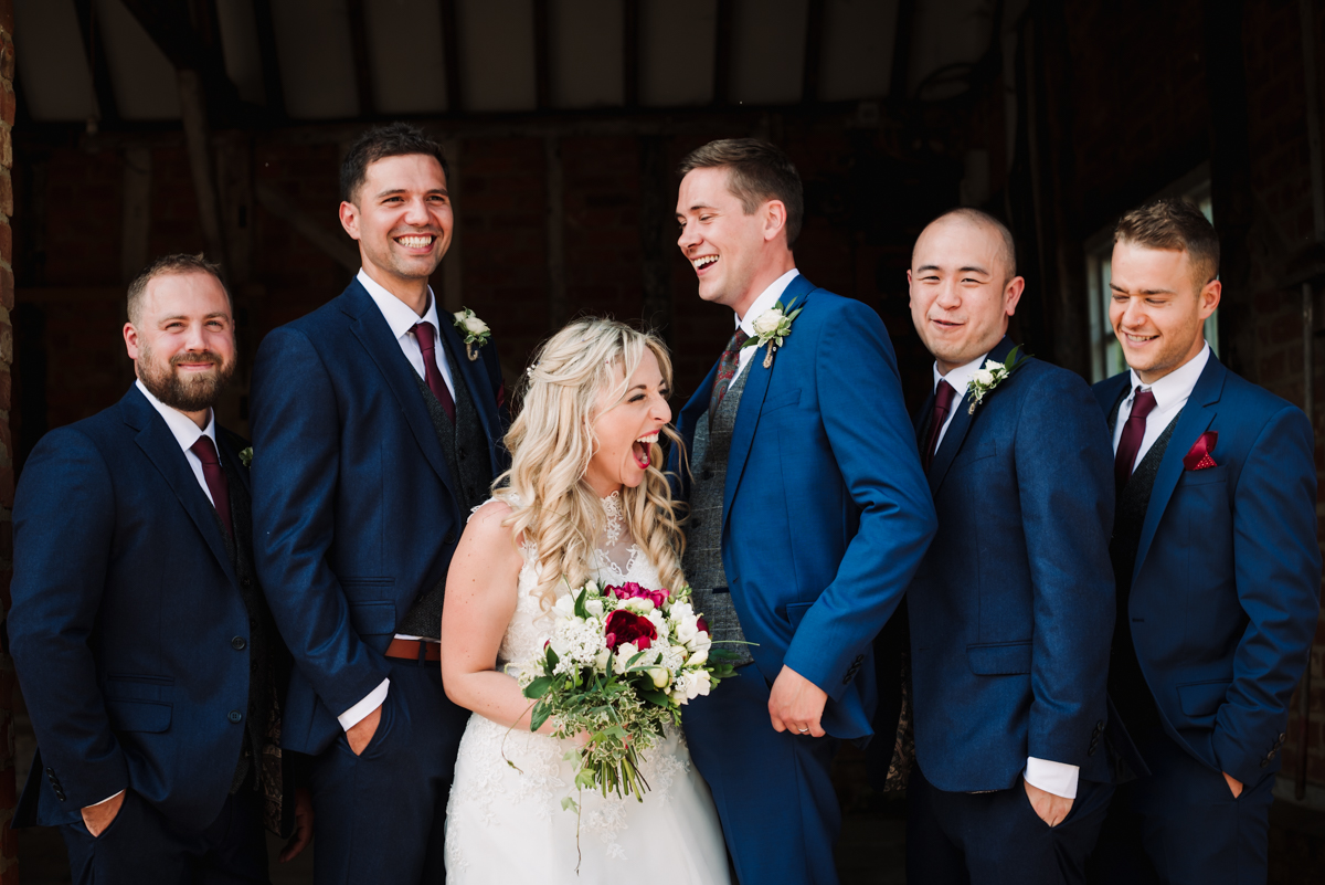 Bride laughs at the groomsmen at Rowley Barn wedding