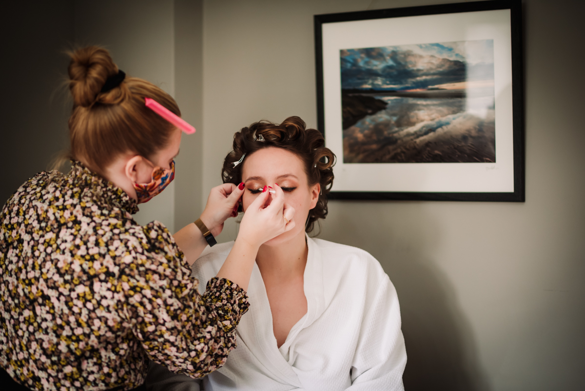 Bride puts on her make up before The Farmhouse at Redcoats wedding