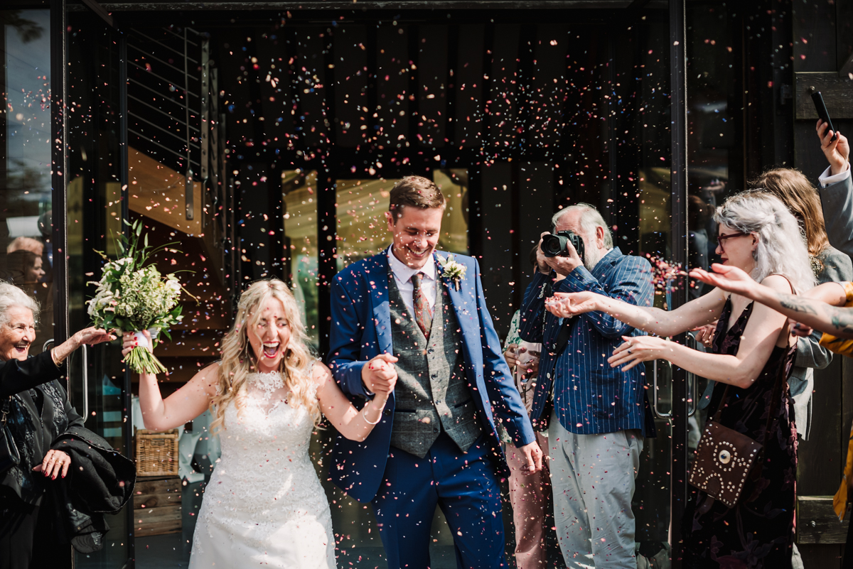 Confetti is thrown by guests after Rowley Barn wedding ceremony
