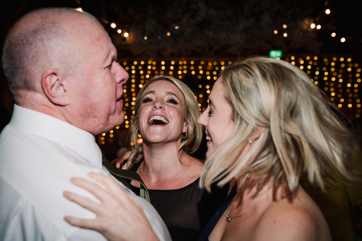 Dancing wedding guests laugh together