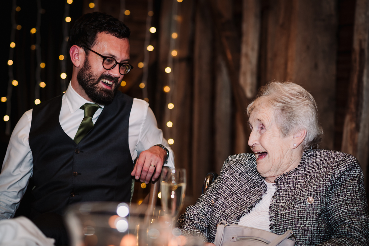 Groom and his grandma laugh together during the speeches at The Barns at Redcoats