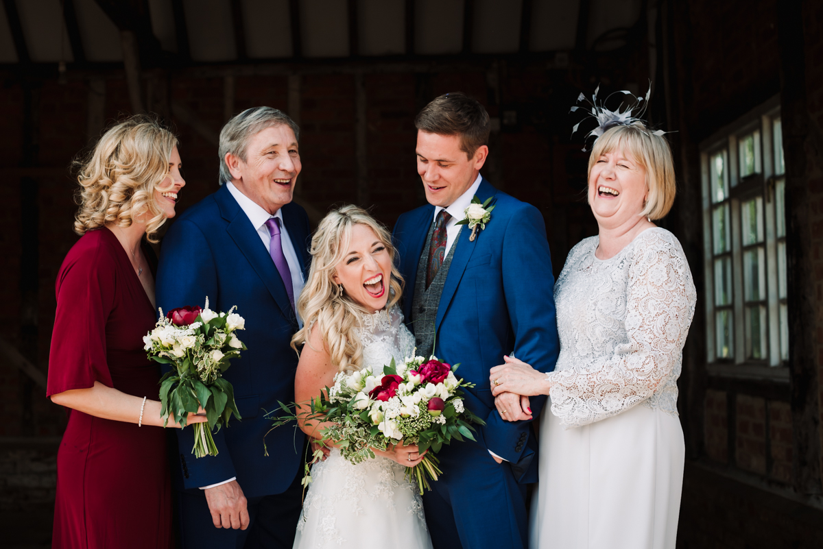 Grooms family share a joke during photos at Rowley Barn wedding.jpg
