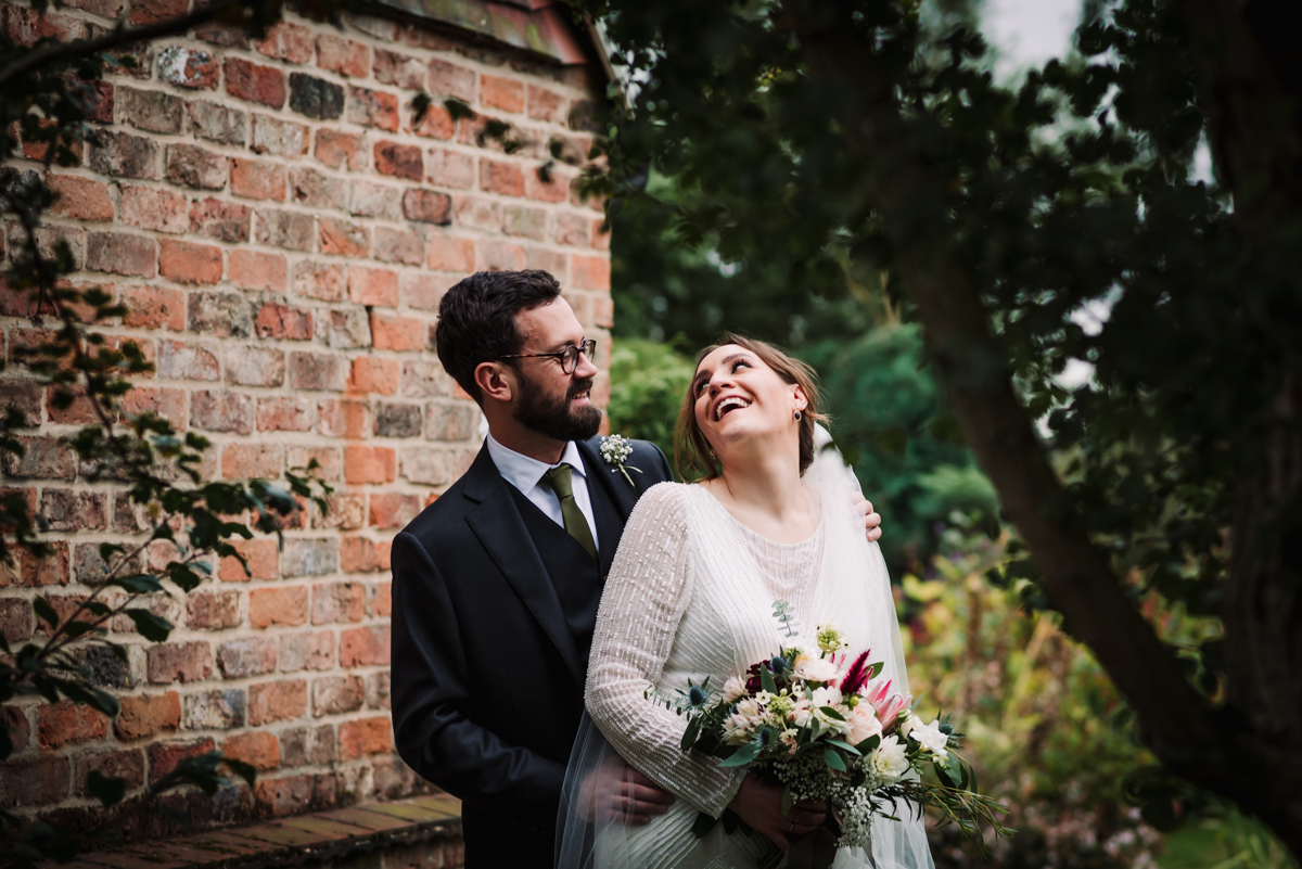 Just married couple laugh in the gardens after their Redcoats Farm wedding ceremony