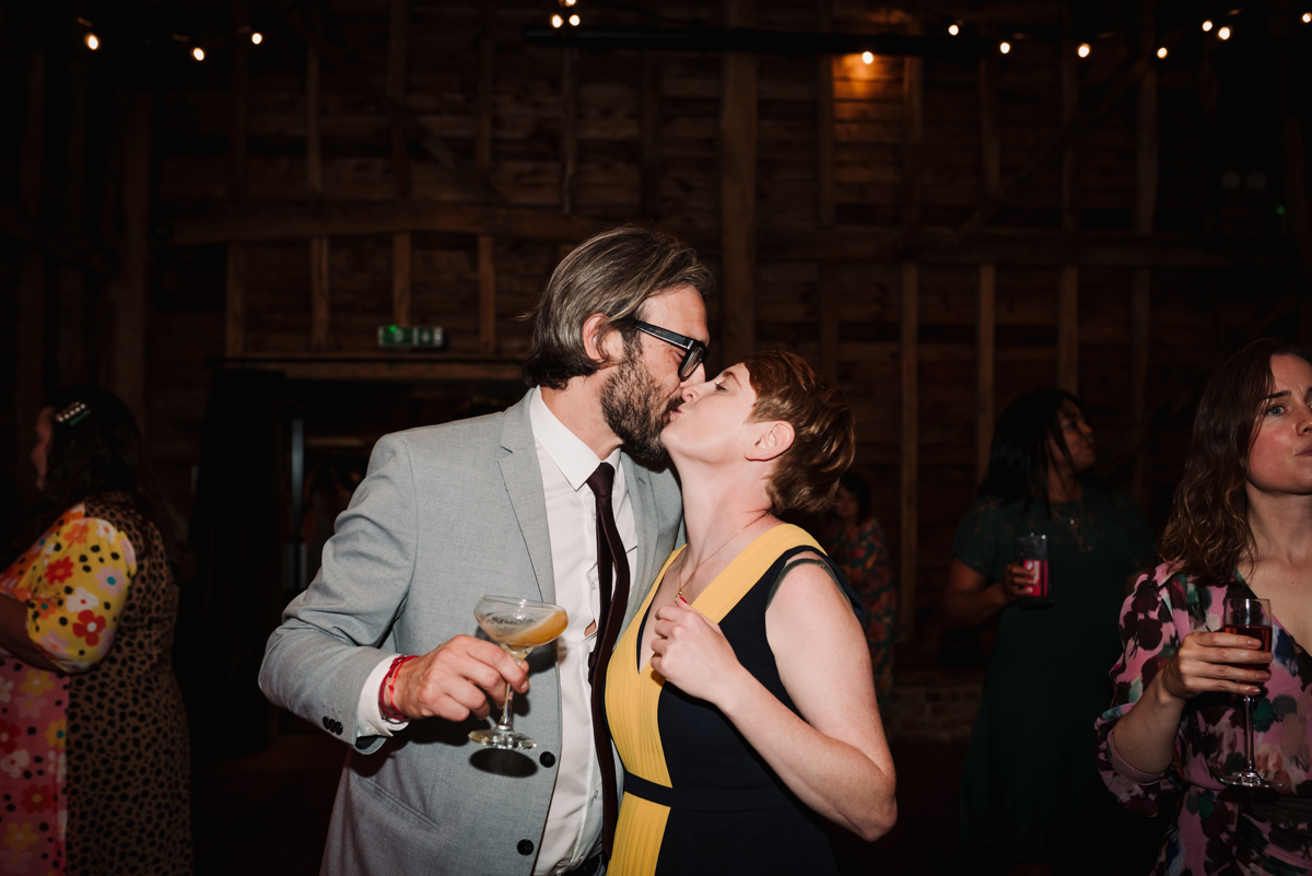 Kissing wedding guests embrace in The Barns