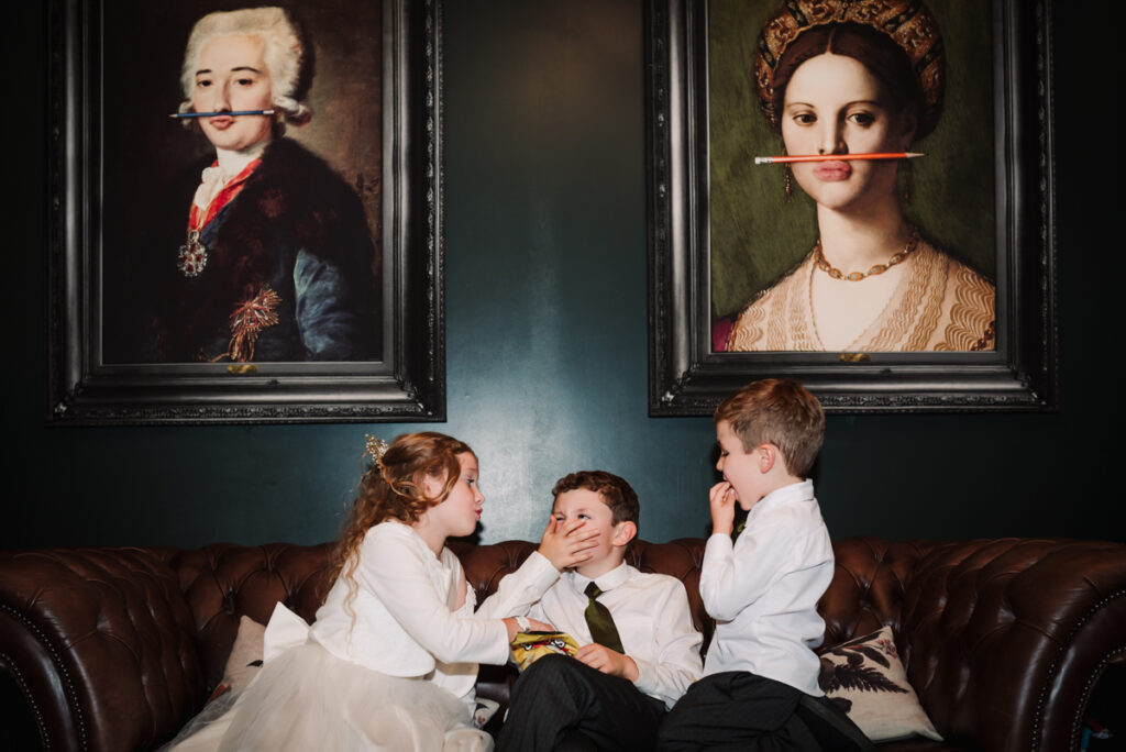 Little wedding guests look mischeivous under the paintings at Redcoats