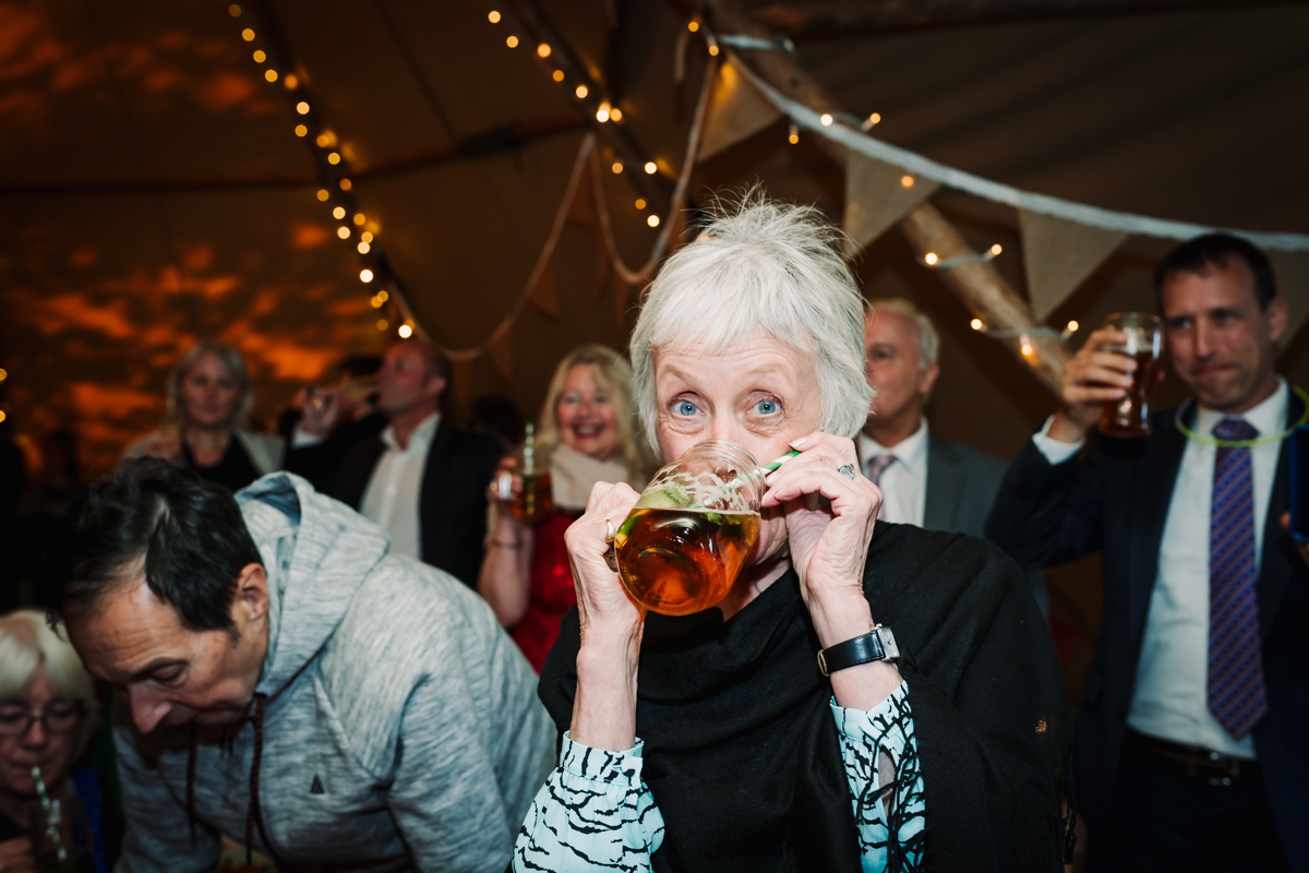 Mother of the bride enjoys a quick drink during the wedding speeches.jpg