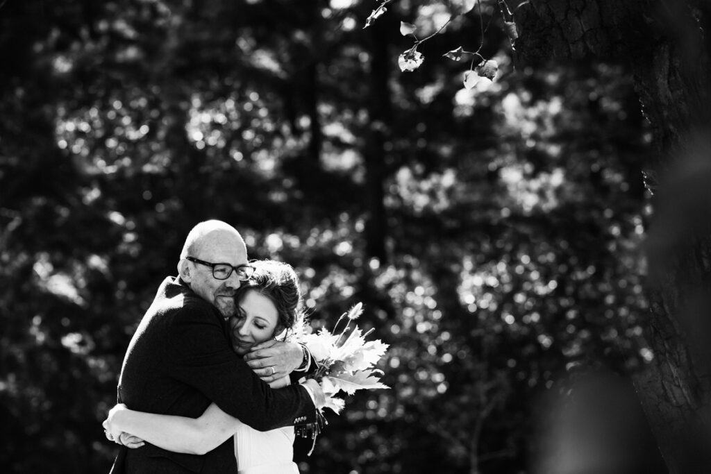 Newmly married couple embrace as their wedding photographer captures the moment