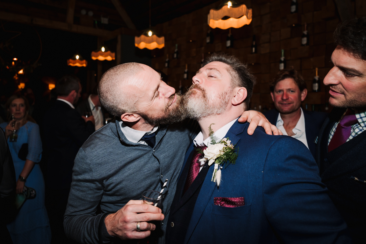 Two bearded wedding guests mess around at Hitchin wedding reception.