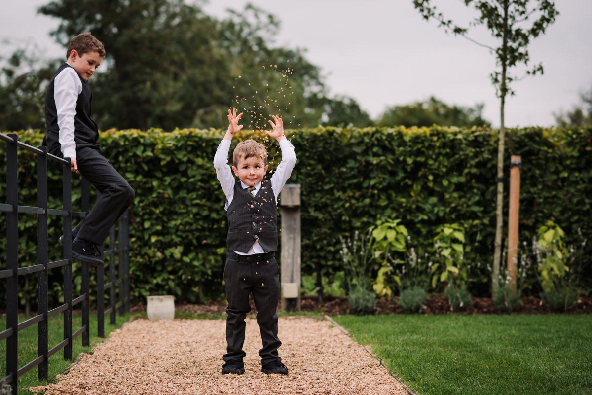 Two little wedding guests throw stones after the Redcoats wedding ceremony