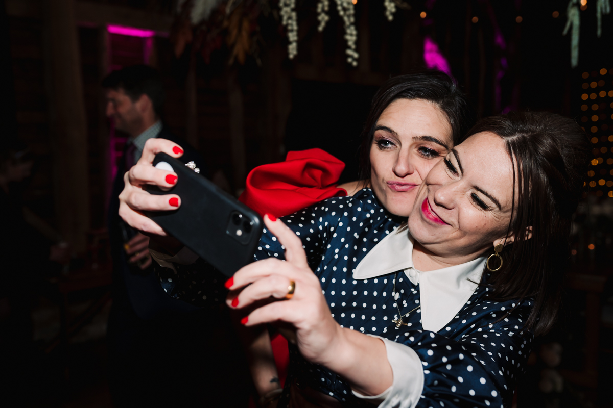 Wedding guests take selfies on the dance floor at Redcoats Farm.
