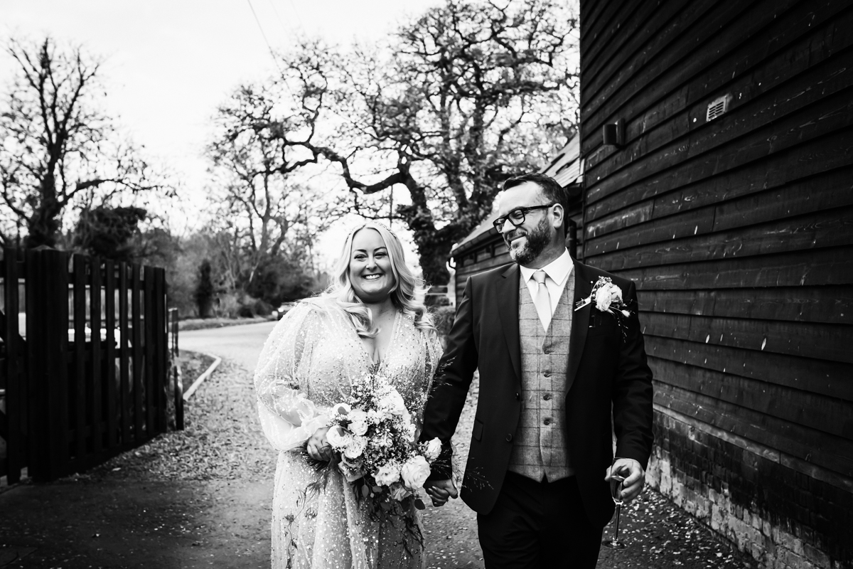 Newly wed couple walk with a wintery backdrop at The Barns at Redcoats in Hitchin