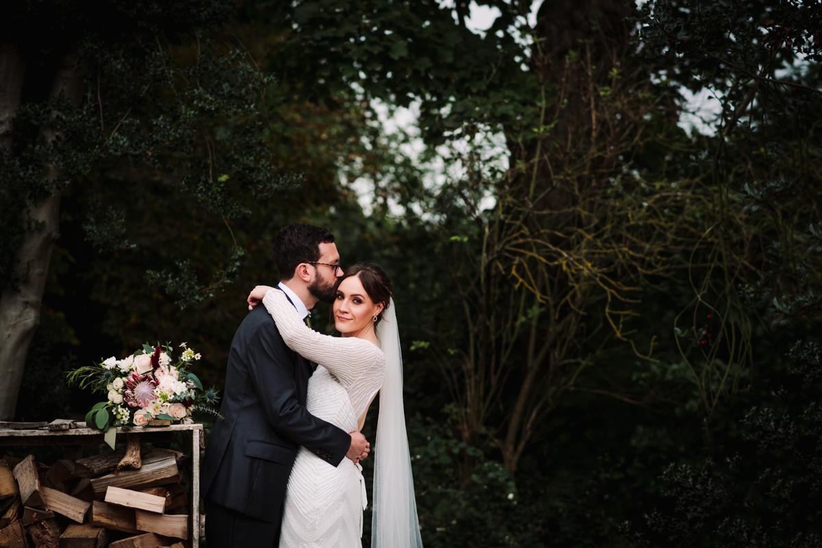 bride and groom hug in the gardens at Redcoats Farm in Hitchin