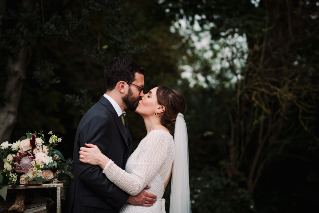 Bride and groom share their first kiss at The Farmhouse at redcoats wedding reception