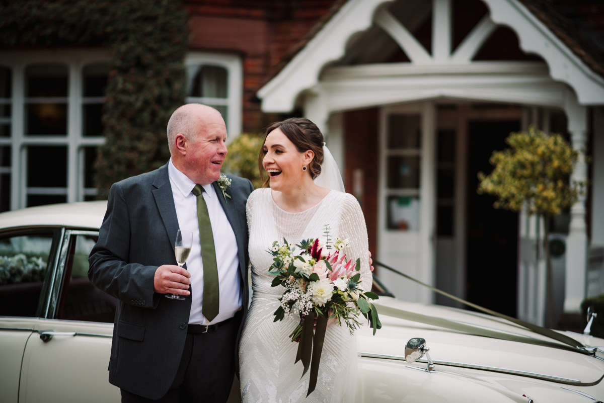 bride and her dad share a joke outside Redcoats Farm