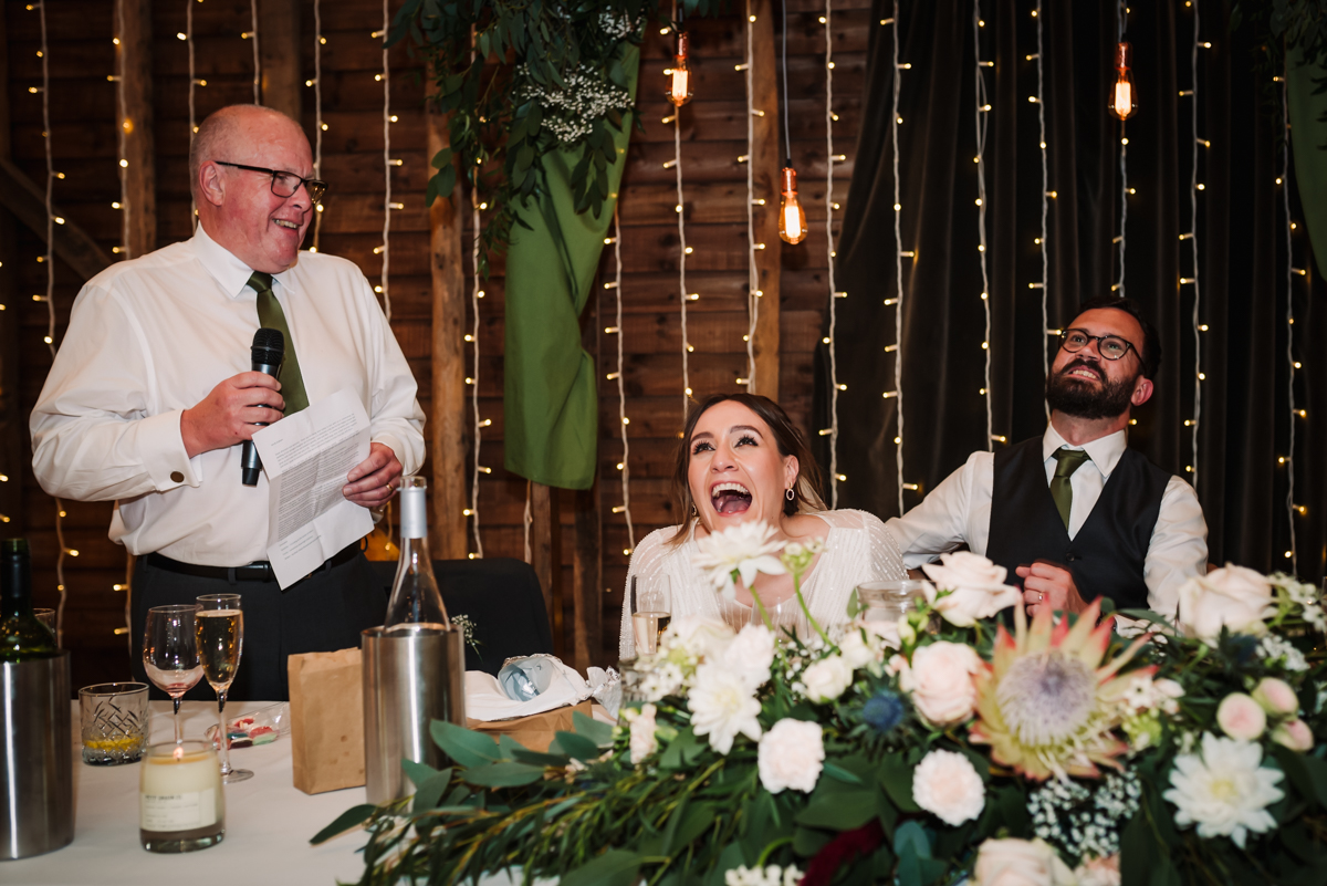 bride laughs heartily at her dads speech at Redcoats Farm in Hitchin