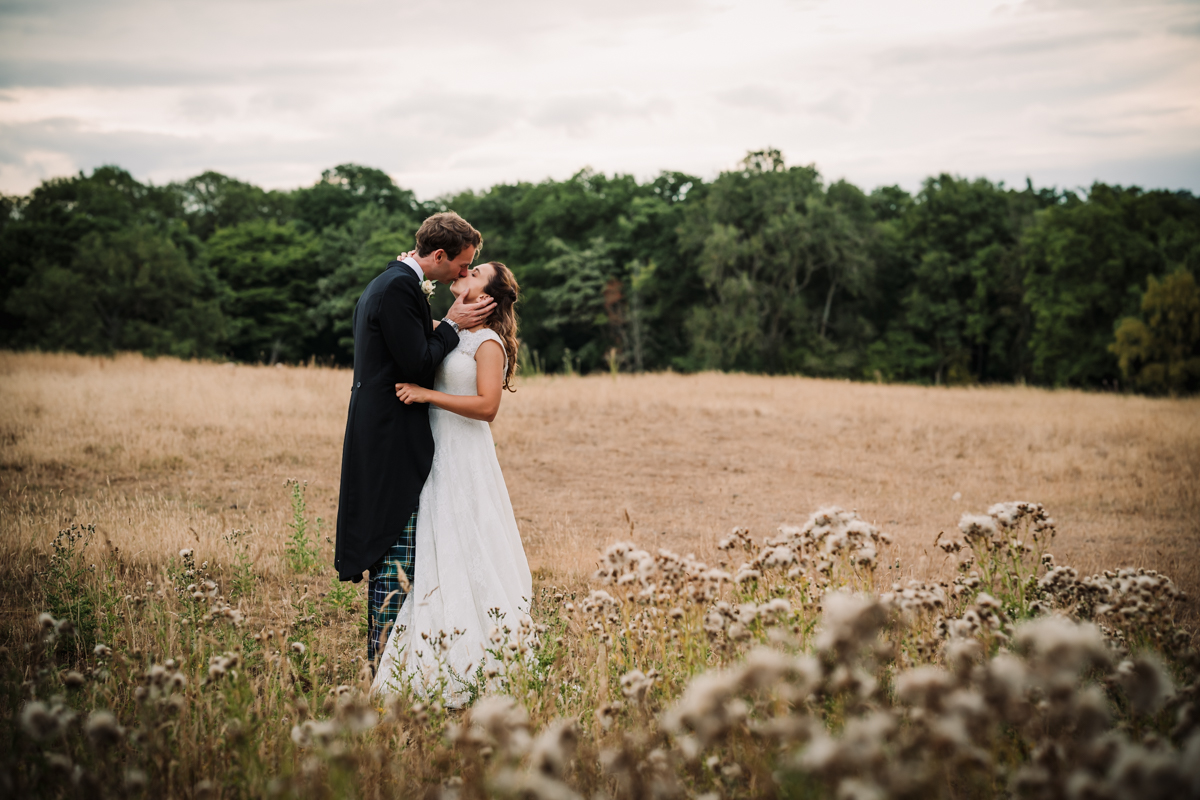 Newly married couple share a kiss during their photography session in Hertfordshire