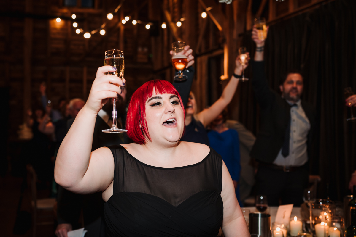 wedding guests raise a toast after speeches at recoats farm in Hertfordshire
