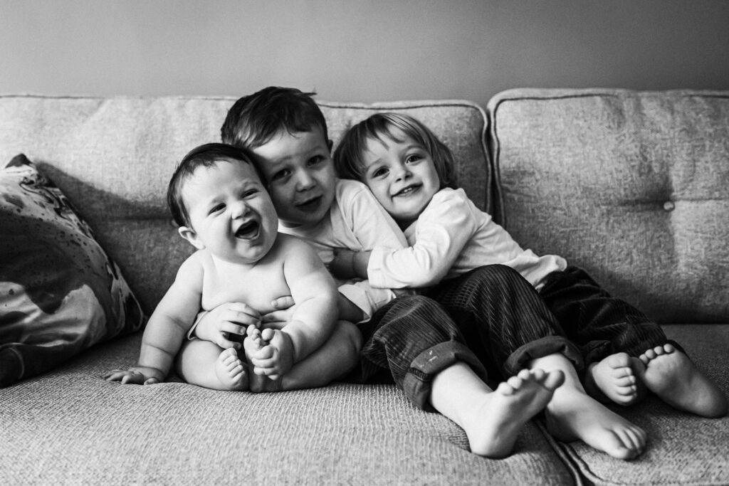 Brothers hug together during a family photo shoot at home