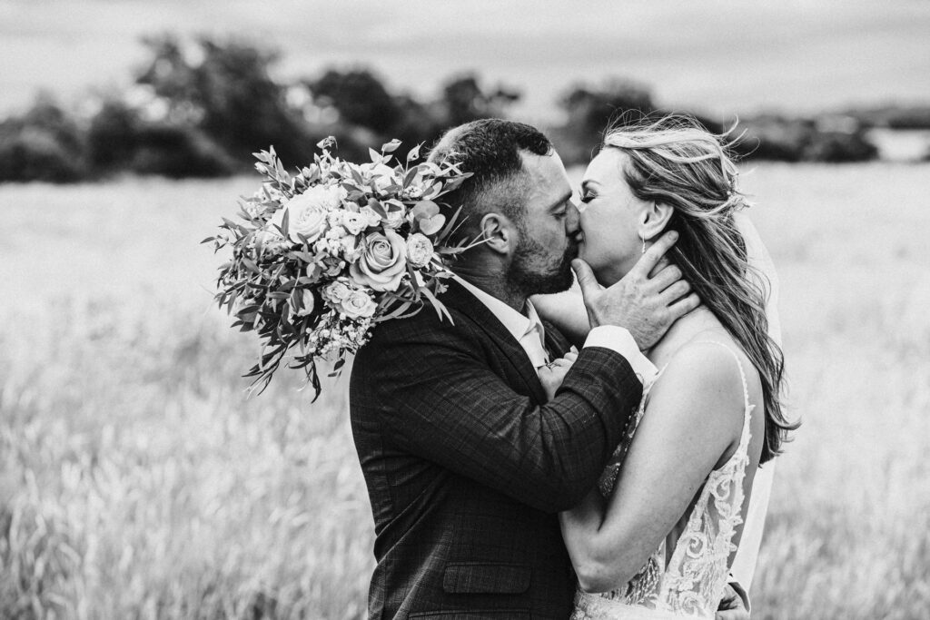 Bride and groom kiss as the wind blows brides hair