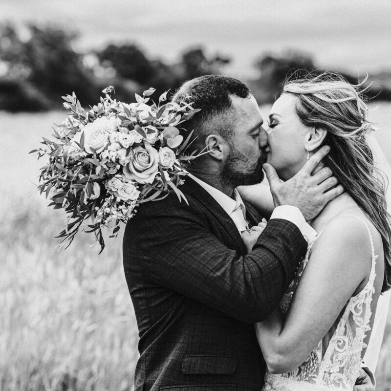 Bride and groom kiss as the wind blows brides hair