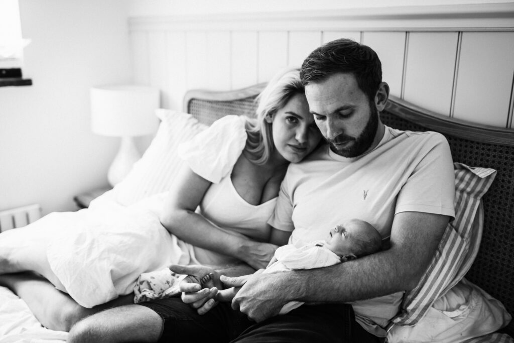 tender cuddle between new parents and their newborn