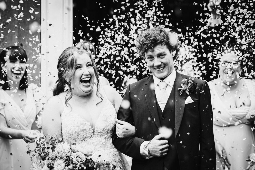 bride and groom enjoy confetti after their Offley Place wedding ceremony