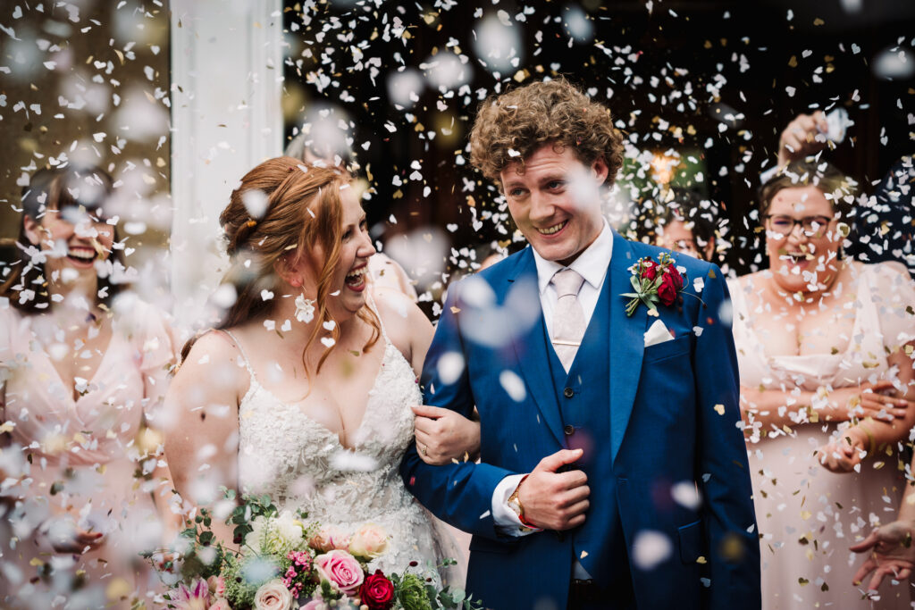 confetti hides the bride and groom after their Hertfordshire wedding ceremony